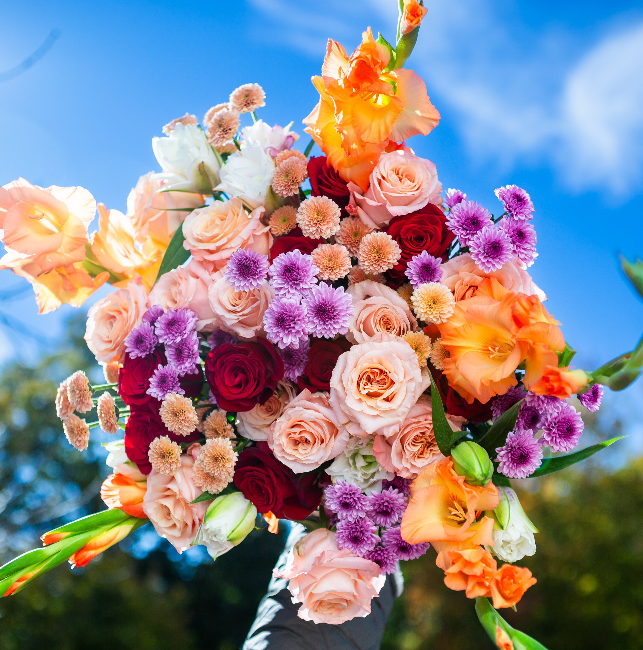 Jellybean — handcrafted hand-tied bouquet with peach gladiolus, blush and red roses, purple mums, and apricot pompoms, Livingston NJ florist